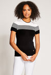 Woman wearing equestrian sweater featuring black and white design with white at shoulders.