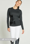 Woman wearing long-sleeve black riding top with lettering reading "Inspire" on the right of the top.