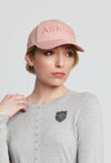 Woman wearing a pink baseball style cap with the word "Asmar" written on the front.