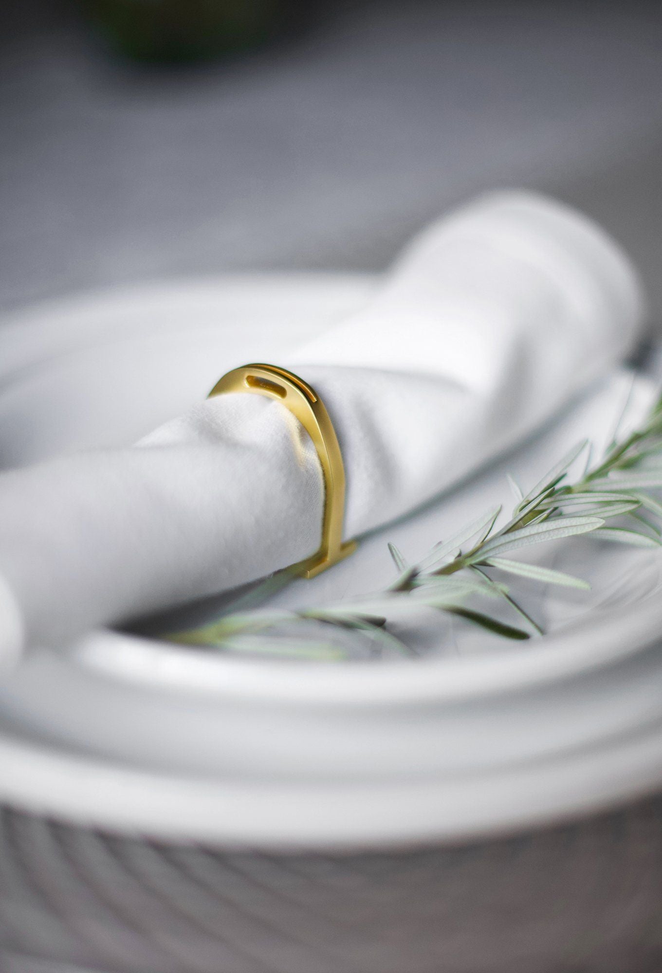 Gold napkin rings holding white napkins.