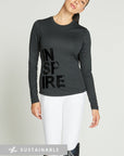 Woman wearing long-sleeve black riding top with lettering reading "Inspire" on the right of the top.
